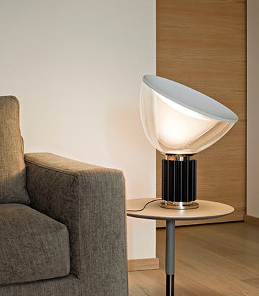 Zeitgenössische Designerleuchte, die sanftes Umgebungslicht neben einem modernen Sofa spendet