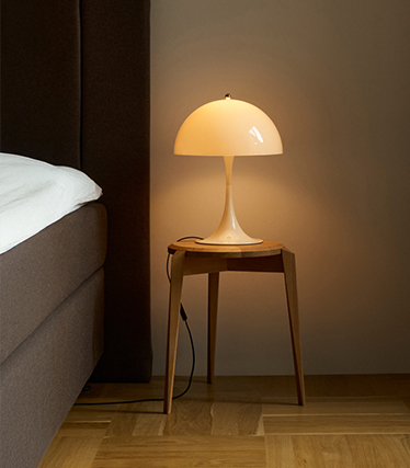 Klassische Pilz-Tischleuchte spendet zartes Licht in einem gemütlichen Schlafzimmer